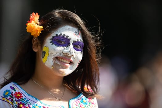 Washington, D.C., USA - September 29, 2018: The Fiesta DC Parade, Mexican woman wearing traditional clothing with face paint as sugar skull