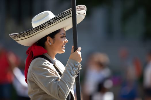 Washington, D.C., USA - September 29, 2018: The Fiesta DC Parade, Mexican woman dress up as charro carrying a banner