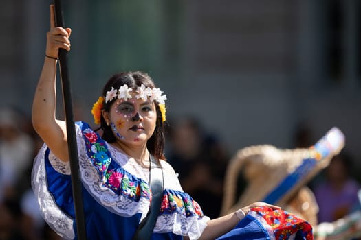 Washington, D.C., USA - September 29, 2018: The Fiesta DC Parade, Mexican woman wearing traditional clothing with face paint as sugar skull