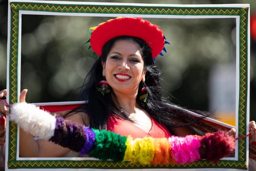 Washington, D.C., USA - September 29, 2018: The Fiesta DC Parade, Peruvian woman wearing traditional clothing holding a frame poses for the camera