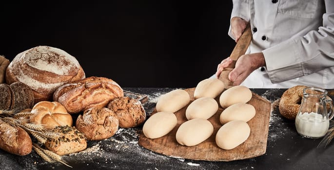 Raw dough for loaves of bread on a wooden paddle ready to be placed in the oven for baking held in the hands of a chef or baker