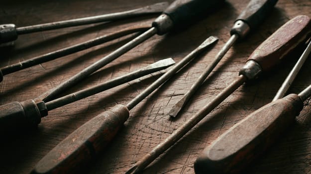 Close up on old worn vintage screwdrivers with rusting metal and worn wood handles in a panorama banner