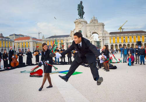 LISBON, PORTUGAL - DECEMBER 10, 2016: Group of teens dressed in traditional students uniform dancing and singing, performing on Commerce square, Lisbon.