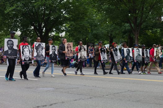 Washington, D.C., USA - May 28, 2018: The National Memorial Day Parade, People carry portraits of world war two military personel down constitution avenue