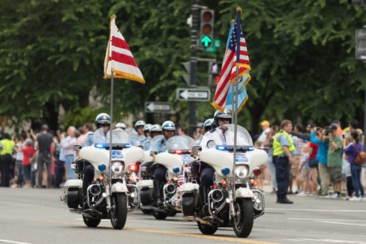 Washington, D.C., USA - May 28, 2018: The National Memorial Day Parade, Members of the Washington D.C. Metropolitan Police, on motorcycles carry the American flag