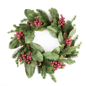 Christmas holiday wreath with pine cones and red berries.