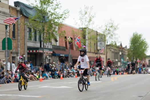 Stoughton, Wisconsin, USA - May 19, 2018: Syttende Mai Youth Parade, Children riding mountain bicycles, with protective gear, during the parade