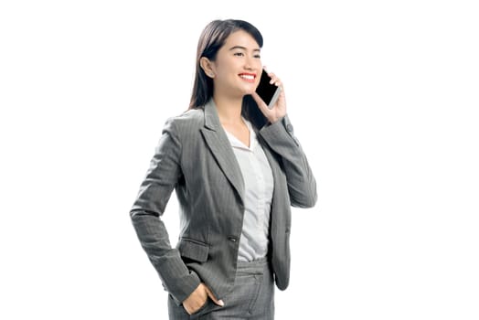 Beautiful asian business woman talking on mobile phone posing isolated over white background