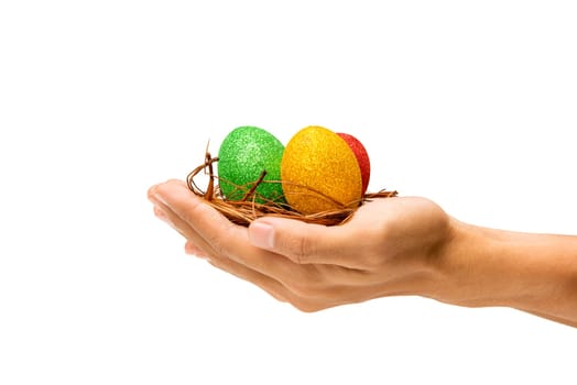 Human hands holding the nest with colorful easter eggs isolated over white background. Happy Easter