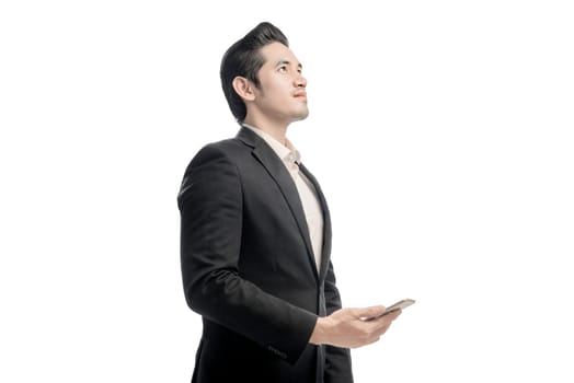 Portrait of asian businessman looking up and holding the mobile phone posing isolated over white background