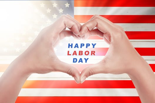 Human hands in heart shape with Happy labor day text over american flag background. Labor day concept