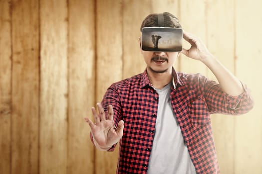 Asian man looking at blurry wild animals with virtual reality device. Augmented reality technology