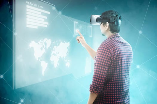 Rear view of asian man touching binary code on digital interface with virtual reality device display the world map, graphic bar and binary code. Augmented reality technology