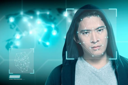 Young asian man in black hoodie using face recognition over digital world map background. Modern technology concept