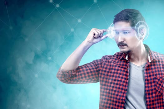 Asian man looking at digital interface with virtual glasses device. Augmented reality technology