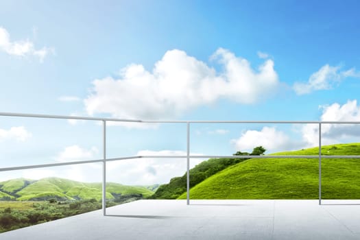 Terrace of building with iron fence and green landscapes view with blue sky background