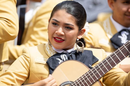 Chicago, Illinois , USA - September 9, 2018 The 26th Street Mexican Independence Parade, mexican women and men wearing traditional mariachi clothing playing the guitar