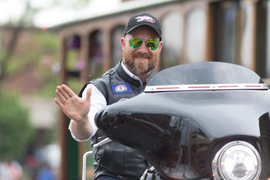 Louisville, Kentucky, USA - May 03, 2018: The Pegasus Parade, Man riding motorcycle waving for the camera