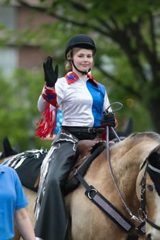 Louisville, Kentucky, USA - May 03, 2018: The Pegasus Parade, members of the Boone County 4-H Equestrian Drill Team, riding horses, carrying flags down W Broadway, during the parade