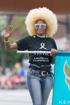 Louisville, Kentucky, USA - May 03, 2018: The Pegasus Parade, African american woman with blonde hair and a shirt that says, Hero a helping hand is a winning hand