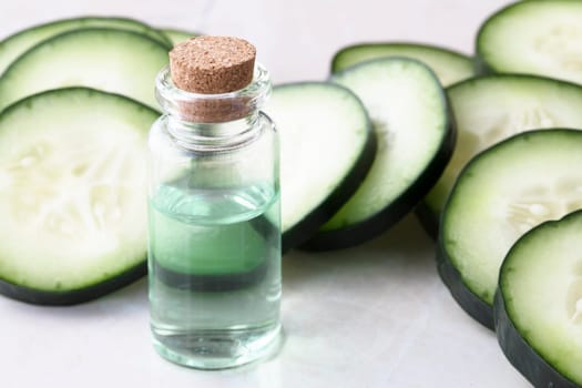 Cucumber slices and small bottle of cucumber extract.