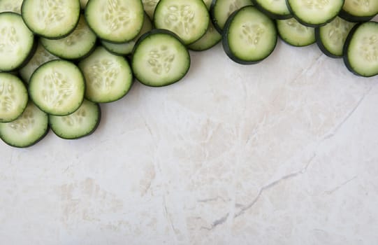 Cucumber slices on marble, flat lay with copy space