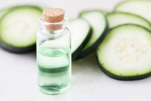 Cucumber slices and small bottle of cucumber extract.