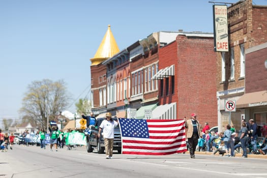 Orleans, Indiana, USA - April 28, 2018: The Orleans DogWood Festival and Parade, two men carrying the american flag during the parade