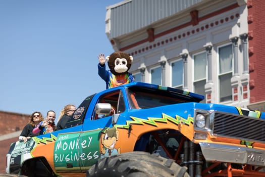 Orleans, Indiana, USA - April 28, 2018: The Orleans DogWood Festival and Parade, A Monster truck with a man dress up as a monkey and a sign that says Monkey Bussines going down the street