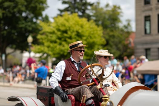 Auburn, Indiana, USA - September 9, 2018 The Auburn Cord Duesenberg Festival, Man and woman with retro cloathing driving An Auburn classic car driving down the street during the parade