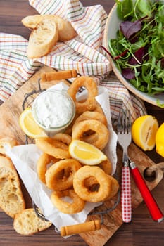 Crispy breaded calamari rings with garlic dip and lemon