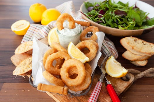 Crispy breaded calamari rings with garlic dip and lemon