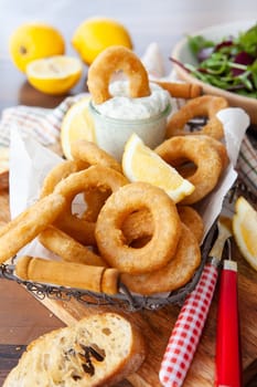 Crispy breaded calamari rings with garlic dip and lemon