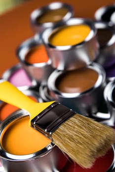 Tin cans with paint, brushes and bright palette of colors