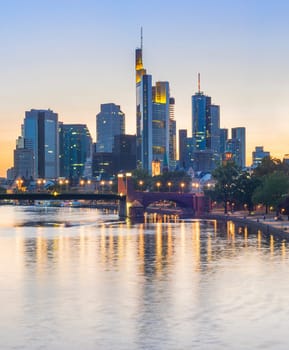 Evening skyline of illuminated Frankfurt downtown with modern architecture at Main river bank, Germany, Europe