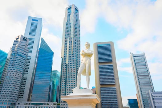Stamford Raffles marble statue and Singapore modern skyline skyward