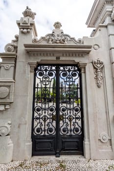 Detail of the gate to the gardens of the sumptuous neoclassical Vale Flor Palace built in early 20th century in Lisbon, Portugal