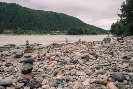 Woman at the river Katun at summer day. Trip on Altai Mountains in Altai Republic