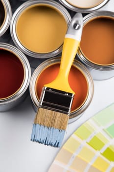 Paintbrush on cans with color