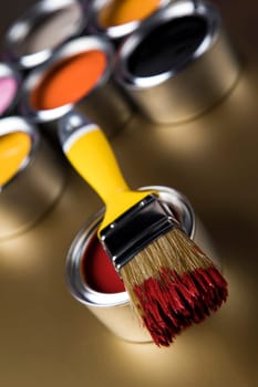 Paintbrush on cans with color
