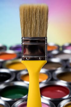Paintbrush on cans with color