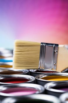 Paintbrush on cans with color