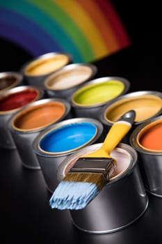 Tin cans with paint, brushes and bright palette of colors