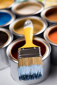 Metal tin cans with color paint and paintbrush