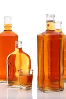 Glass cup and bottle of whiskey on white background
