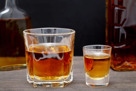 glass cup and bottle of whiskey on a old wooden table