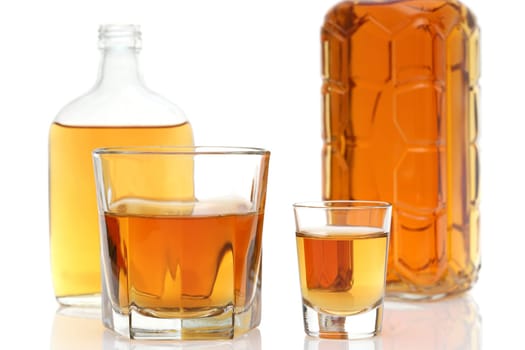 Glass cup and bottle of whiskey on white background