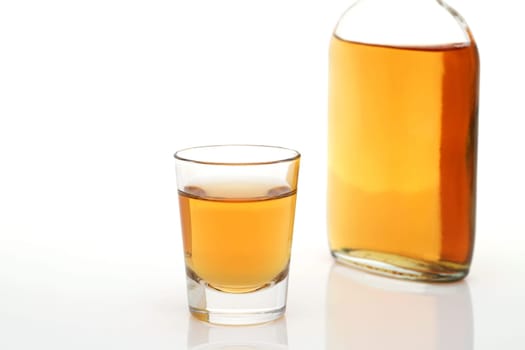 Glass cup and bottle of whiskey on white background