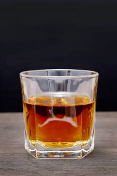 Glass cup of whiskey on a old wooden table