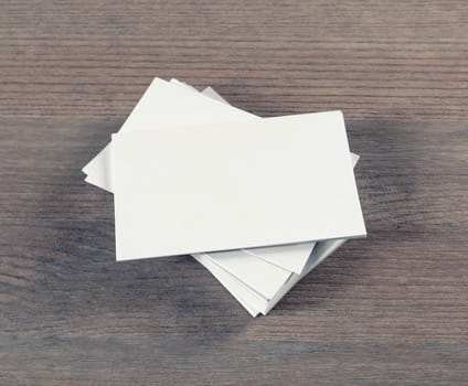 Photo of blank business cards on wooden background. Template for branding identity.